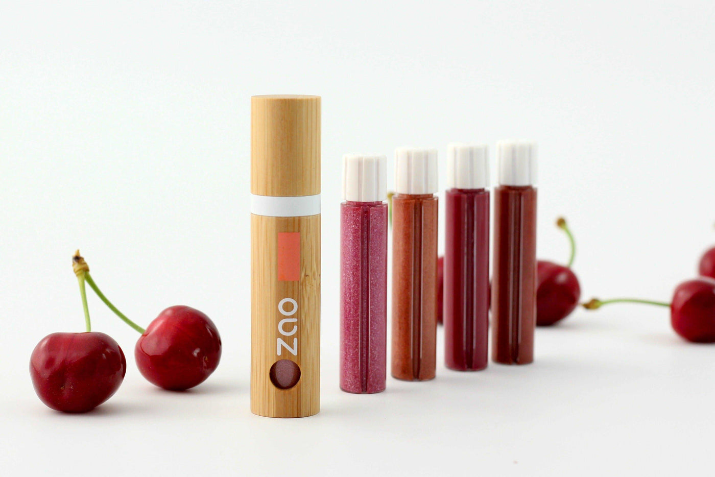 Lip Gloss von ZAO essence of nature, vorne in Bambus Verpackung hinten aufgereiht die verschiedenen Farben als Refills