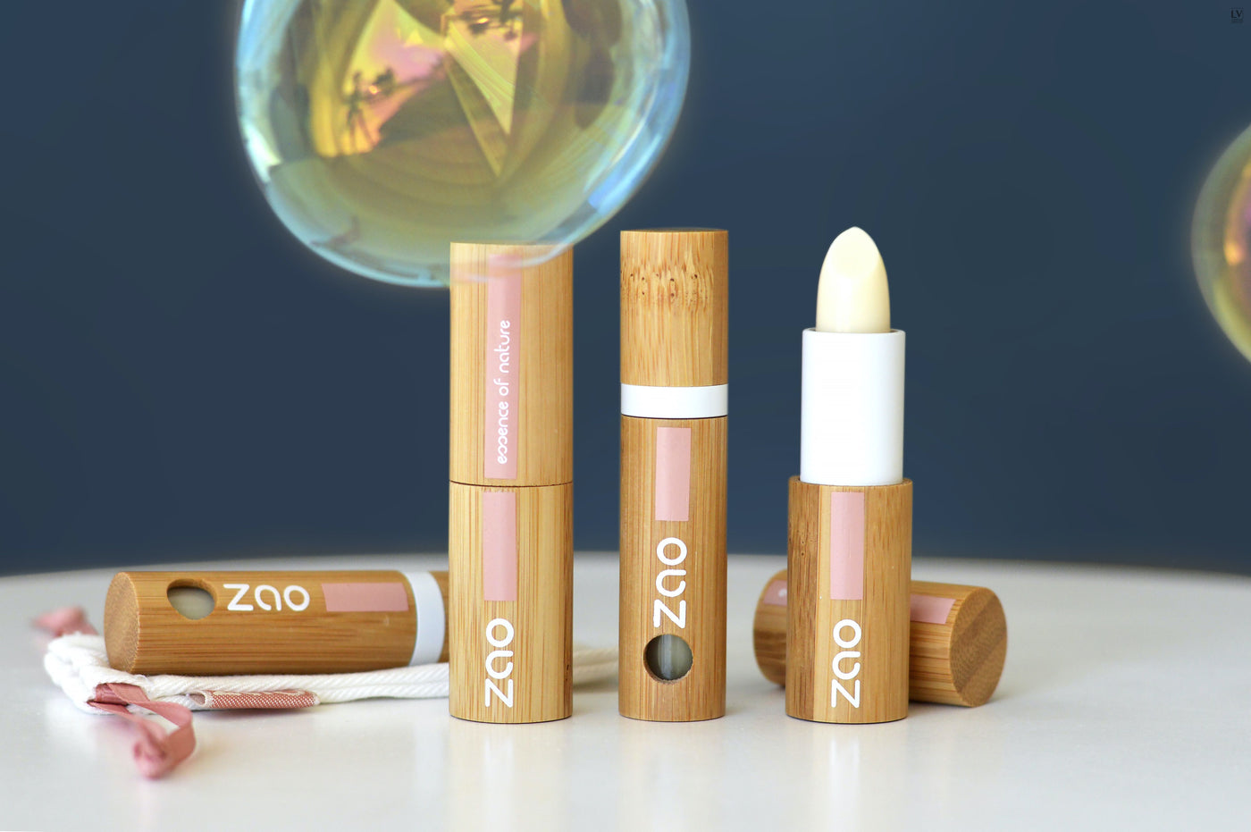 Lip Balm Stick, Lip Care Oil und Liquid Lip Balm aufgestellt mit Seifenblasen im Hintergrund